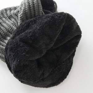Close-up of grey knit hat showing warm black plush faux fur lining and thick texture