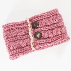 Detailed close-up of pink cable knit headband with wooden buttons and lace trim edges