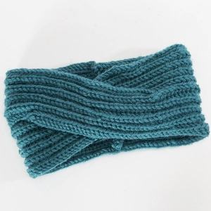 Close-up of chunky knit cross-knot headband in deep teal blue for winter warmth