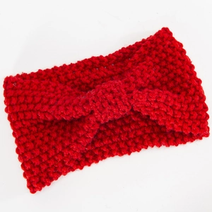 Makro-Detail von rotem Strickstirnband mit grober Webstruktur und Mittelknoten
