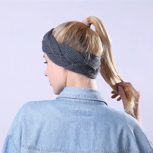 Detail of dark grey cable knit headband on model showing thick wool texture and warmth