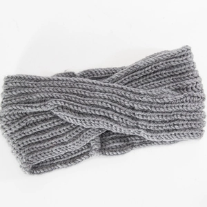 Close-up of grey knitted headband with twisted design and chunky cable knit texture