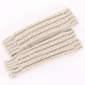 Gros plan de mitaines en tricot torsadé beige montrant la texture épaisse et douce en laine