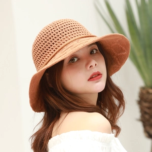 Close-up of caramel crochet sun hat showing intricate hollow knit patterns and wavy brim