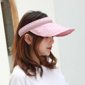 Detail of pink visor with white polka dots and geometric chain pattern headband