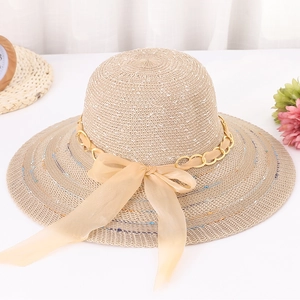 Détail d'un chapeau de soleil beige avec chaîne dorée et nœud en organza champagne
