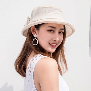 Close-up of elegant cream organza sun hat featuring a delicate side bow and floral mesh