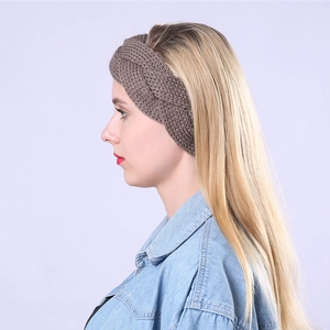 Detailed knit texture of a brown braided wool headband on a model for winter warmth