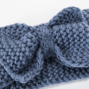 Macro della fascia in maglia blu che mostra il dettaglio del fiocco e la trama