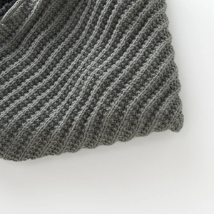 Detailed close-up of dark grey thick ribbed knit fabric with warm wool texture