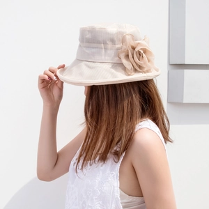 Close-up of a large decorative mesh flower on an elegant beige organza sun hat