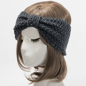 Detaillierte Strickstruktur eines dunkelgrauen Wollstirnbands mit modischem Knoten