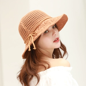 Detail of caramel crochet sun hat featuring knit diamond pattern and bow decoration
