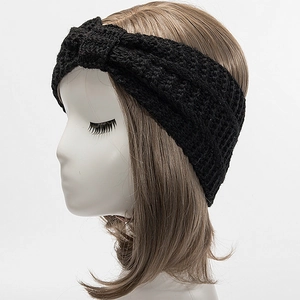 Close-up of black twist knot knitted headband showing thick ribbed texture for winter