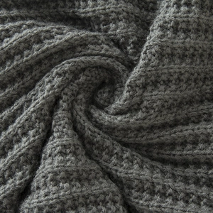 Detailed macro view of dark grey waffle knit fabric with thick fleece lining and ribbing