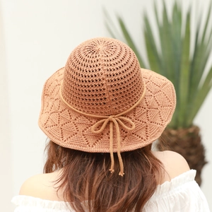 Detail of knitted crochet bucket hat with diamond mesh pattern and chic bow decoration
