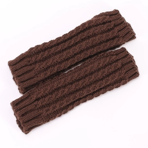 Gros plan détaillé de mitaines en tricot torsadé marron foncé avec texture côtelée