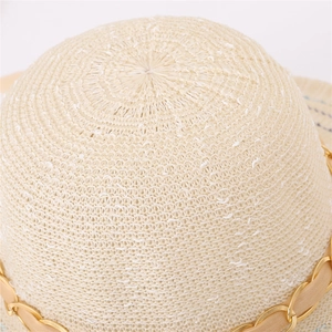 Détail d'un chapeau de paille avec chaîne dorée élégante et ruban de décoration
