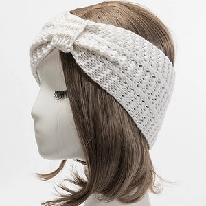 Detail of soft cream-white knitted headband with elegant cross-knot design texture