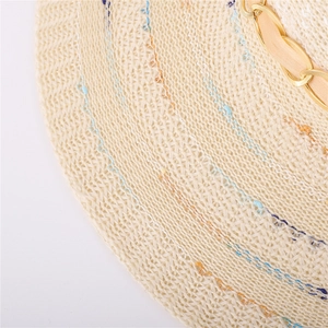 Détail d'un chapeau de soleil montrant le tissage fin, les coutures et la chaîne dorée