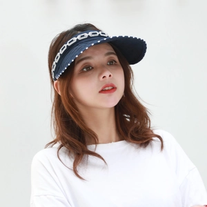 Detail of dark blue sun visor with white chain pattern and polka dot brim on model