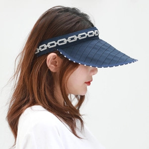 Detail of navy sun visor featuring quilted brim and silver jacquard chain patterns