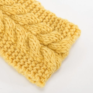 Detalle macro de la textura de punto trenzado amarillo jengibre en una diadema de invierno