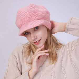 Close-up of pink cable knit texture on a thick winter beanie with a visor for women