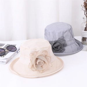 Detailed view of elegant organza flower accents on beige and grey wide brim sun hats