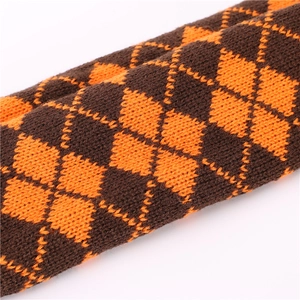 Vue macro du tricot à losanges sur les mitaines tricotées marron et orange