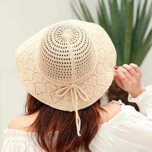 Detail of hand-woven cotton sun hat with delicate bow accent and airy knit pattern
