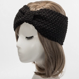 Detailaufnahme eines schwarzen, grob gestrickten Twist-Stirnbands mit weicher Textur
