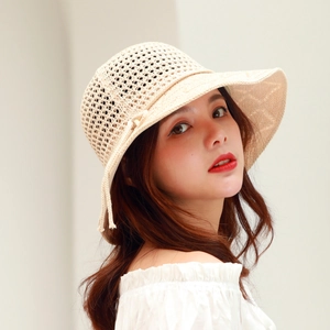 Detail of beige crochet knit pattern and side decorative ribbon on sun hat