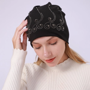 Detail of black cotton slouchy beanie featuring elegant silver rhinestone wave patterns