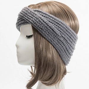 Detailed close-up of grey chunky knit headband with cross design on female model