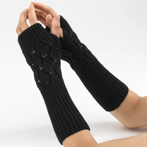 Dettaglio di guanti in maglia nera senza dita con elegante motivo a rombi traforati