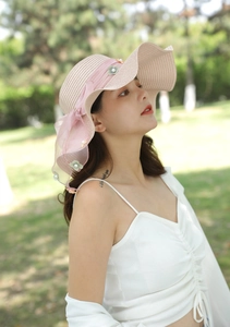 Vista dettagliata del cappello di paglia rosa con fiori 3D e nastro in rete elegante