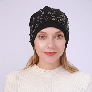 Detail of black cotton beanie featuring intricate silver pearl and rhinestone scroll pattern