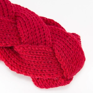 Macro detail of red cable knit headband showing thick wool texture and craftsmanship