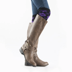 Detalle de botas altas marrones de piel sintética con correas cruzadas y hebillas de moda