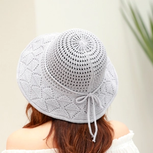 Detail of grey knitted sun hat with diamond pattern, hollow knit and elegant bow