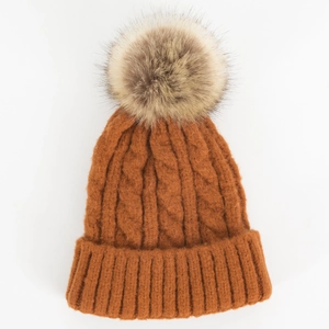 Thick knit cable beanie with large pom-pom in caramel yellow for winter warmth
