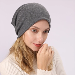 Detailed view of dark grey slouchy beanie with vertical rows of sparkling rhinestones