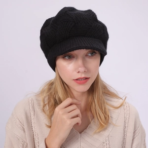Detailed view of thick black cable knit newsboy cap with ribbed brim for winter