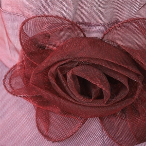 Detail of elegant dark red organza flower with delicate mesh layers on a sun hat