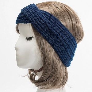 Detail view of the navy blue hand-knitted headband with a twist design on a model