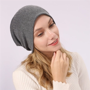 Detailed view of grey slouchy beanie with silver rhinestone vertical stripe patterns