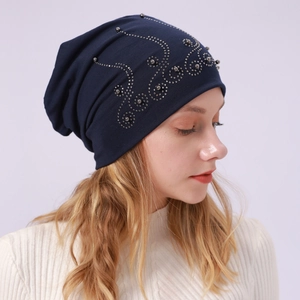 Detail of navy blue slouchy cotton beanie featuring intricate silver rhinestone swirl patterns