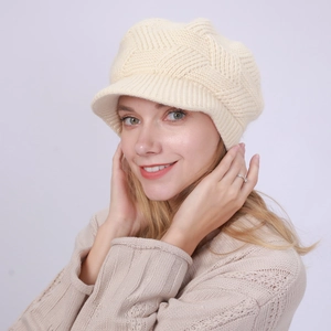 Close-up of cream knit peaked cap showing twill texture and warm plush lining