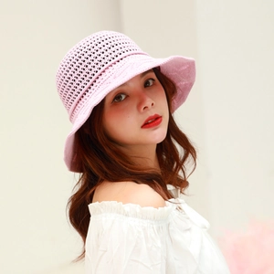 Close-up of pink knit bucket hat with hollow-out pattern and scalloped wavy brim